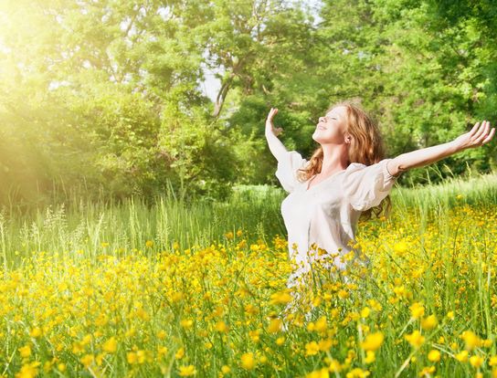 Mujer en la naturaleza liberada de energías negativas